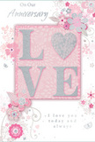 The photo presents an anniversary card that celebrates lasting love with the softness of a Covent Garden morning, blending pastel blush pinks, muted silvery greys, and crisp white accents. At the centre is the word LOVE, beautifully spelled out in raised, glitter-soft letters, so that each curve and edge appears lightly dusted with sparkle. The letter O is transformed into a silver-textured heart, gleaming slightly more brightly than the surrounding glitter, like a small jewelled charm set into the card. Around this romantic focal point, delicate blossoms unfurl across the surface in shades of blush and mauve, their petals painted with an almost watercolour touch. Fine, flowing lines define each flower and leaf, while slender tendrils and curling vines arc gracefully from cluster to cluster. Tiny flourishes-floating petals, gentle swirls, and subtle butterfly motifs-add a hint of whimsy, reminiscent of flower stalls and street performers that bring life to the nearby market piazza. The text On Our Anniversary appears in refined script, balanced carefully with the lower phrase I love you today and always, each letterform echoing the curves of the floral swirls. The overall mood is one of quiet celebration and shared history, as if the card were meant to rest beside a vase of locally arranged blooms, perhaps delivered by a Covent Garden florist to a home overlooking cobbled streets. It feels both intimate and polished, a paper counterpart to the fresh, fragrant arrangements found throughout this vibrant London neighbourhood.